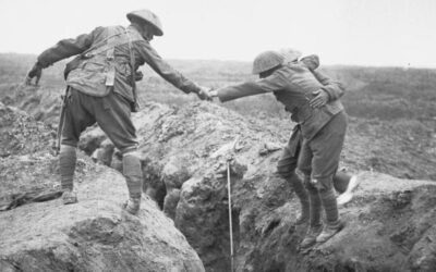 Cabhraíonn beirt shaighdiúirí le saighdiúir leonta trinse a thrasnu, two soldiers lelp a wounded copmrade across a trench.